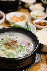  clay pot of soondae gukbap (blood sausage soup) with steamed rice and assorted banchan, such as...