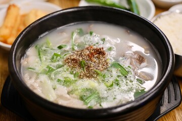  clay pot of dweji gukbap (pork soup), a regional specialty from Gyeongsang Province, with steamed rice and assorted banchan, such as kimchi, at Yeodongsik - a Korean restaurant in Sydney, Australia