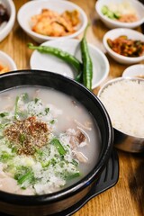 A clay pot of soondae gukbap (blood sausage soup) with steamed rice and assorted banchan, such as kimchi and green chilli peppers, at Yeodongsik - a Korean restaurant in Sydney, Australia