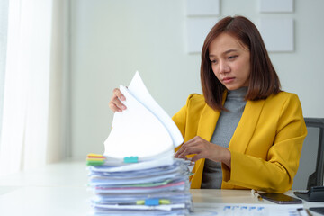 Female independent businesswoman, female office worker working with documents in the workplace Asian businesswoman sitting in modern office with documents and laptop computer.