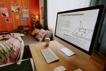 No people shot of modern desktop computer with Math lesson on screen in modern teen students room interior, copy space