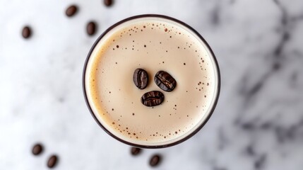 Top-down view of an Espresso Martini with a garnish of three coffee beans on a marble background