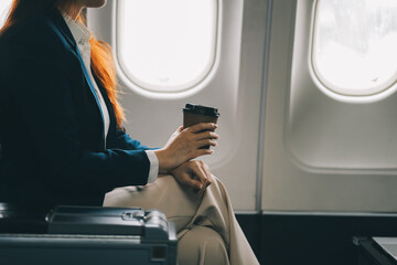 Asian woman sitting in a seat in airplane and looking out the window going on a trip vacation travel concept.Capture the allure of wanderlust with this stunning image