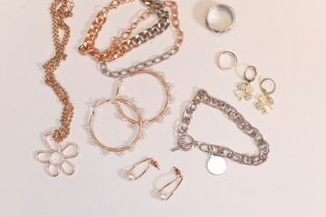 Gold and silver jewellery. Pastel Background