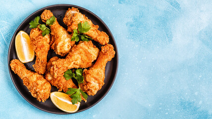 Fried chicken legs with lemon and parsley.