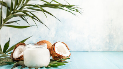 Coconut oil and coconuts on a bright pastel background.
