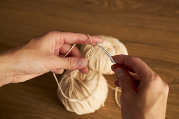 two skeins of yarn for knitting and hook on the table 