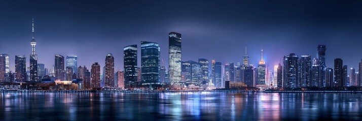 Naklejka premium A breathtaking panoramic view of a modern city skyline at night, with buildings glowing and reflections shimmering on the water's surface.