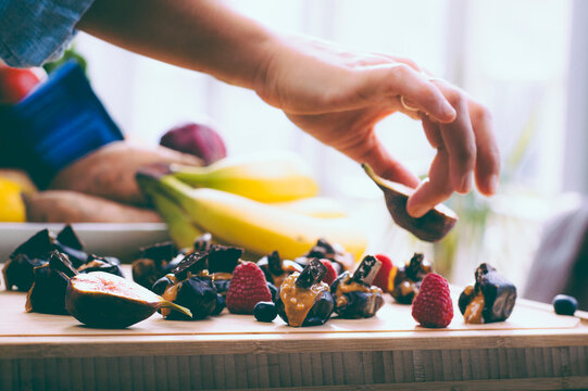 Healthy Kitchen - woman prepares dates, raspberries, and peanut butter