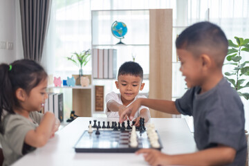 Fototapeta premium Two children playing a game of chess. One is a boy and the other is a girl. They are sitting at a table with a chess board in front of them