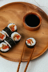 Japanese sushi roll with salmon on a wooden plate