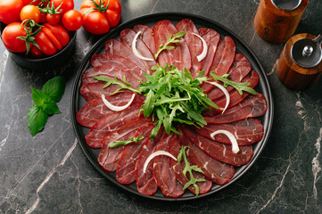 marble beef carpaccio on a black plate
