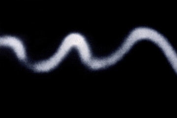 wavy line of white spray paint on black paper background