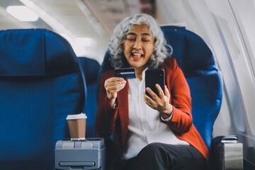 An adult woman sits by the window on a passenger plane, eagerly traveling abroad. She gazes at the...