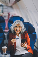 An adult woman sits by the window on a passenger plane, eagerly traveling abroad. She gazes at the clouds, anticipating new experiences and adventures in a foreign land.