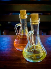 Two glass bottles with vinegar and oil on a table