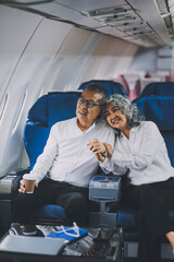 Happy elderly senior couple of travelers with suitcase in airport