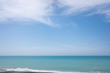 Blue sea and blue sky with white clouds. Seascape.