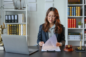 Young Asian legal advisor or lawyer reviewing business contracts or life insurance contracts for...
