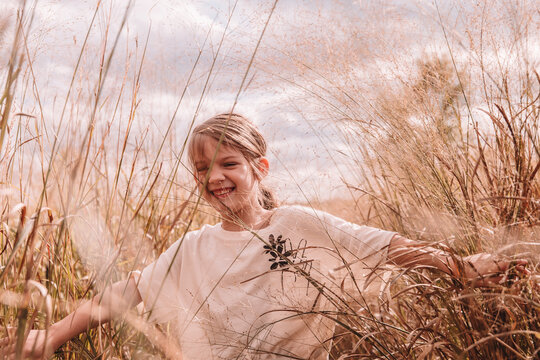 7 year old walking in a field with her hair in a ponytail