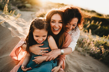 Three generations laughing women mom grandma girl beach sunset Spain