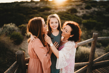 Three generations hugging women mom grandma girl beach sunset Spain