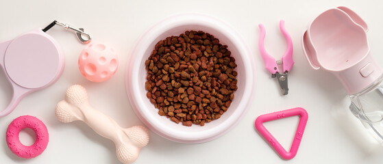Stylish pet accessories set in pink hues, includes food bowl, toys and grooming tools. Perfect for modern pet owners