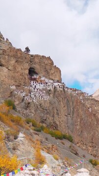 Vertical shot of ancient Phugtal Monastery made in a natural cave near Purne village in Zanskar, Ladakh India. Old Buddhist monastery with flowing blue Tsarap river. Nature Landscape. 