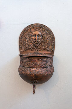 copper hand sink on a white wall in Stefan Batory's castle in Grodno, Belarus.