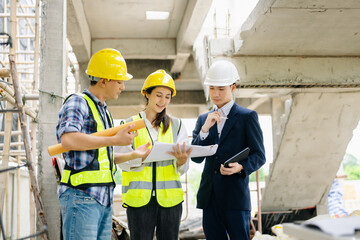 Contractor and architect looking at plan, tablet, laptop and talking about working on big project.