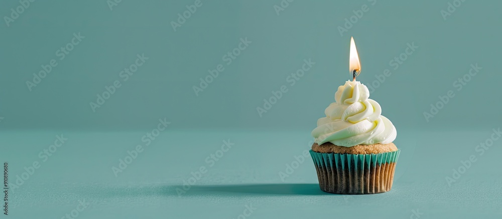 Poster a tasty cupcake with a lit candle is placed on a soft green backdrop leaving room for a message in t
