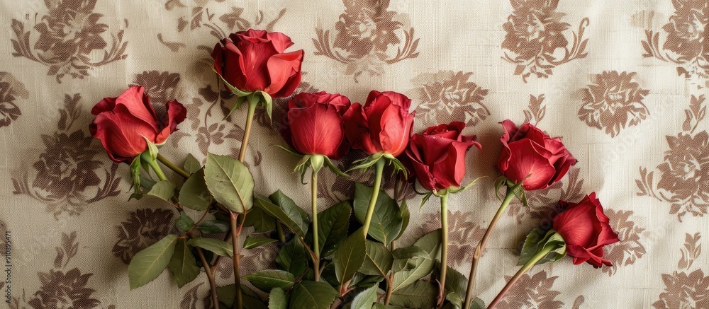Aufkleber A top down shot of a group of red roses lying on a patterned light brown background Picture with room for text. Creative banner. Copyspace image