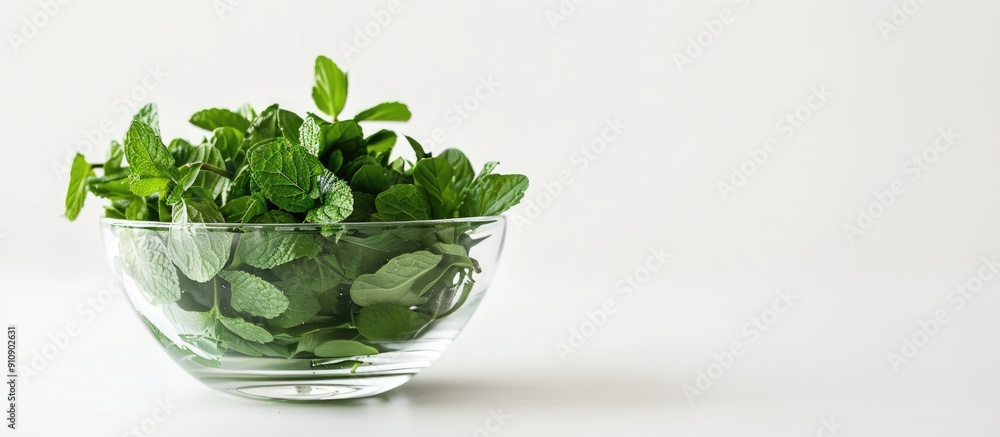 Poster fresh mint herbs in a glass bowl on a white background perfect for adding text or images with its co
