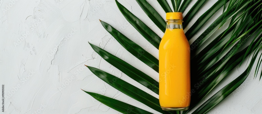 Aufkleber a yellow mango smoothie is showcased on a white background served in a bottle alongside a palm leaf 