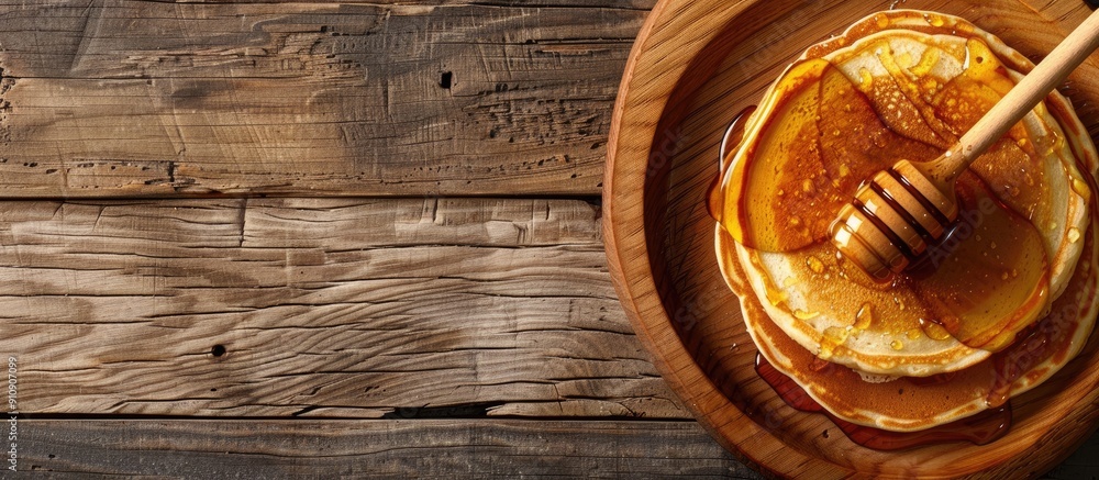 Poster wooden table with pancakes drizzled in honey featuring ample copy space image