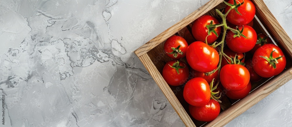 Poster Wooden box filled with vibrant red tomatoes on a light backdrop highlighting eco friendly theme and shot from above for copy space image