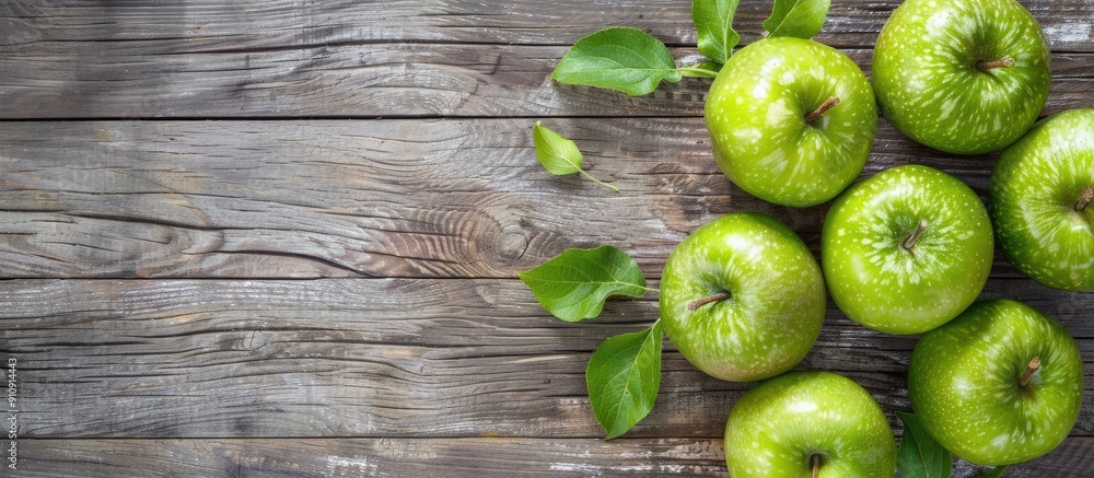 Poster Fresh green apples displayed on a rustic wooden surface with ample copy space image