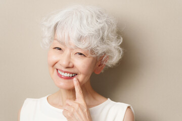 白い歯を指差す高齢者女性
