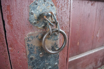 Ancient Circle metal door handle on red door.