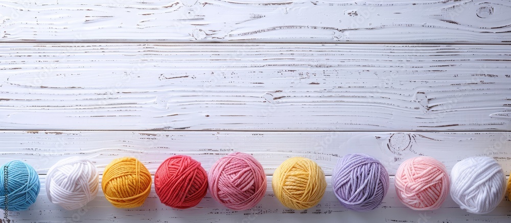 Poster Woolen yarn balls arranged neatly on a clean white wooden tabletop providing ample copy space image