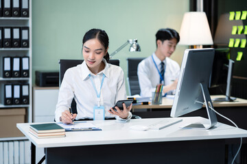 Asian employee working at office with laptop and documents on desk, People Work in Business Office.