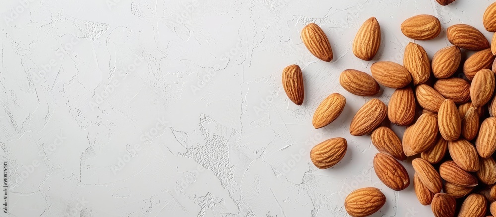 Poster An overhead shot of almond nuts stacked on a white surface with room for text or graphics such as a copy space image