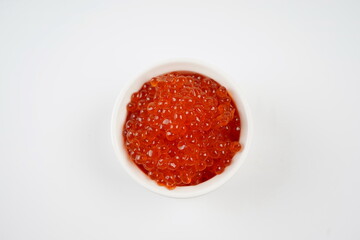 Salmon Red Caviar. Red fish caviar  in white bowl. Raw seafood. Luxury delicacy food. White background.
