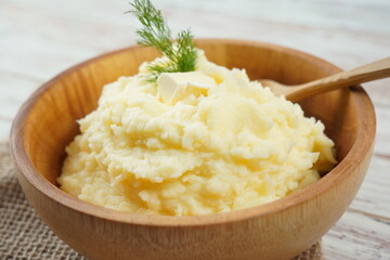 Bowl of tasty mashed potatoes with fresh dill served on wooden table