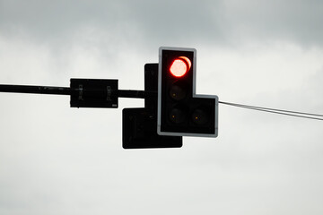 A traffic light with a red light and a white sign that says L