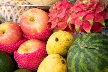 A bunch of fruit including apples, watermelon, and dragon fruit