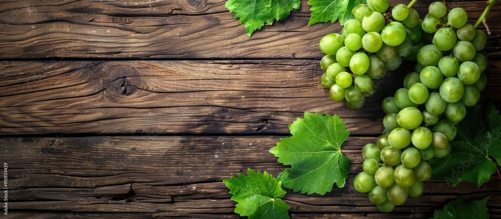 Aufkleber Fresh green grapes with a bunch and vine leaf displayed on a wooden background in a top view flat lay style with copy space image