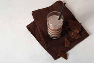 Glass of sweet chocolate milk on white background