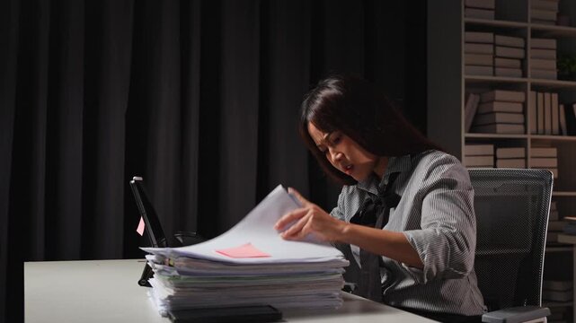 Asian businesswoman who is tired and stressed from paperwork Headache with business work failed growth Not according to plan Tired of sitting at a desk for a long time. Office Syndrome concept.