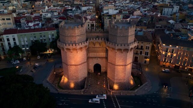 Aerial view of Valencia at night, Torres de Serranos medieval gate in Valencia with night illumination drone view, tourism in Spain and Catalunya 